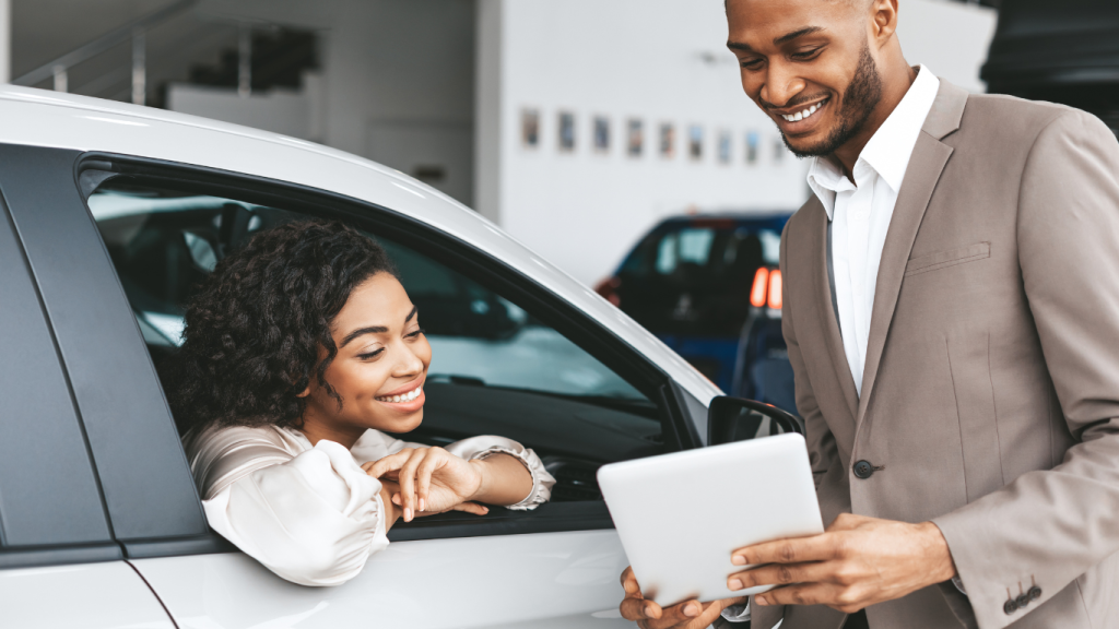 African American Woman Buying Car In Auto Dealership Center